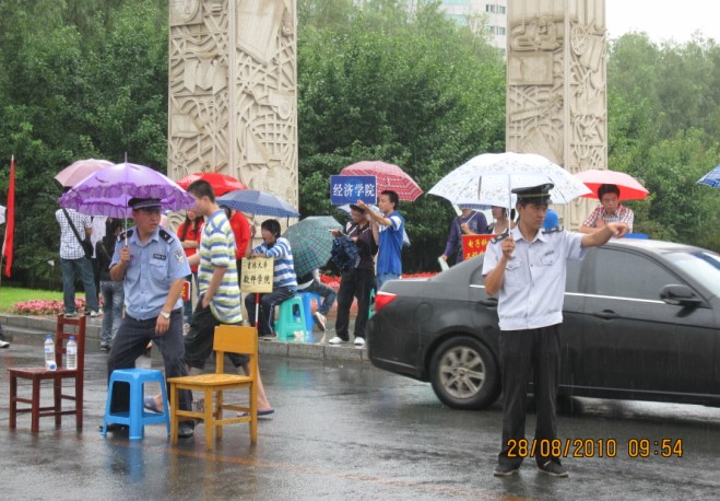 保卫处工作人员在雨中疏导交通